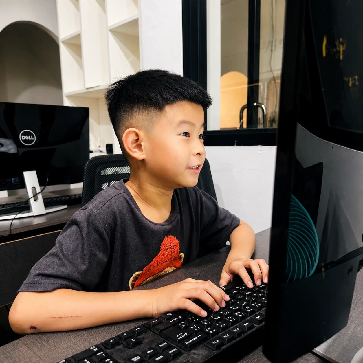 Young boy learning computer basics at a Nura Dev desktop station