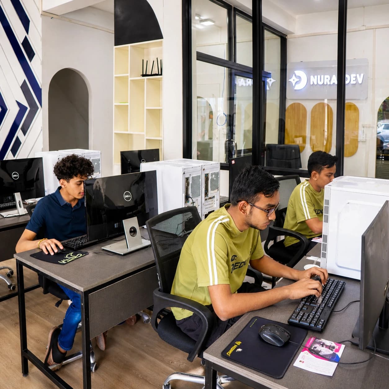 Teen learners practicing computer skills in the Nura Dev lab
